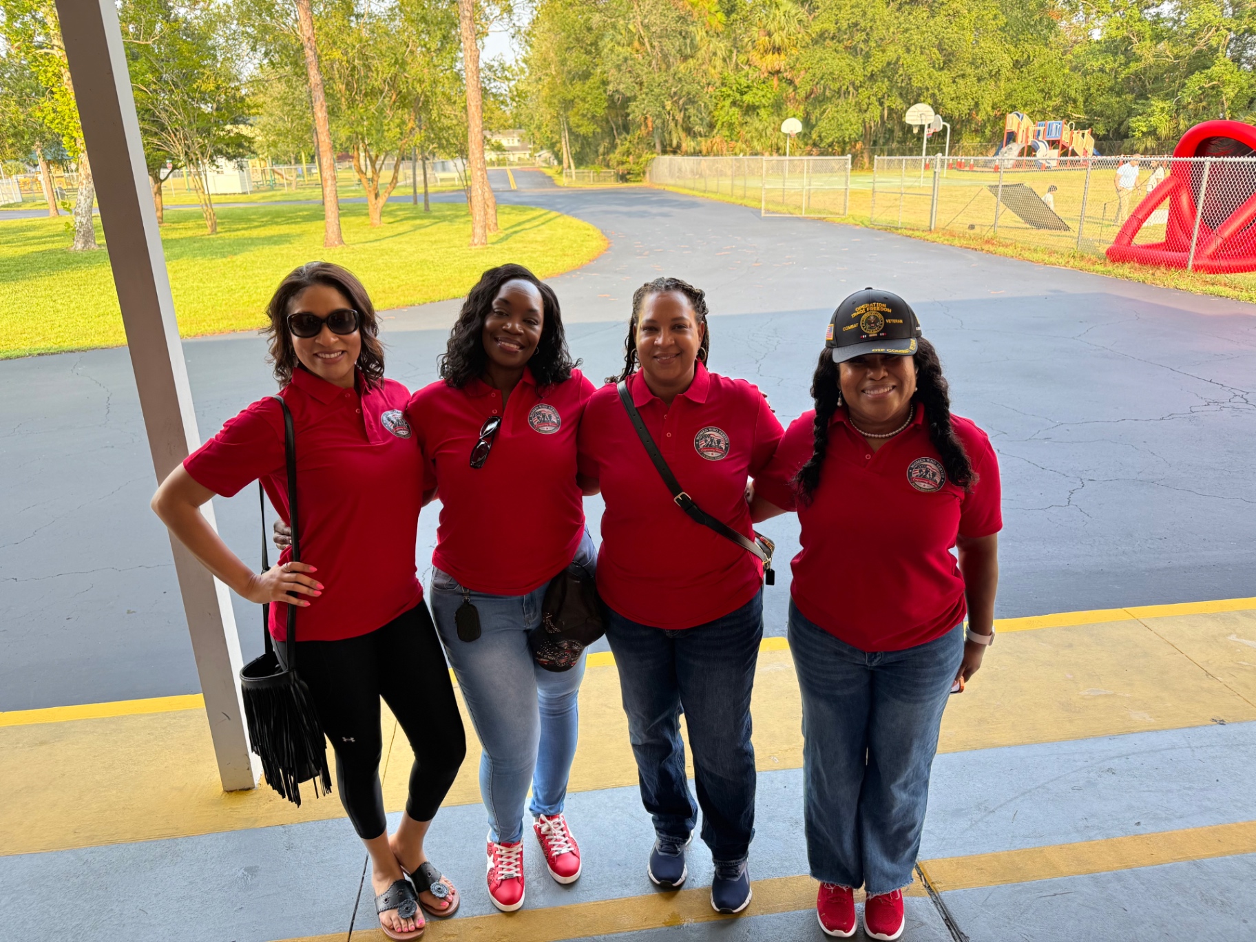 Women Who Served Alliance members in red polos at a community event